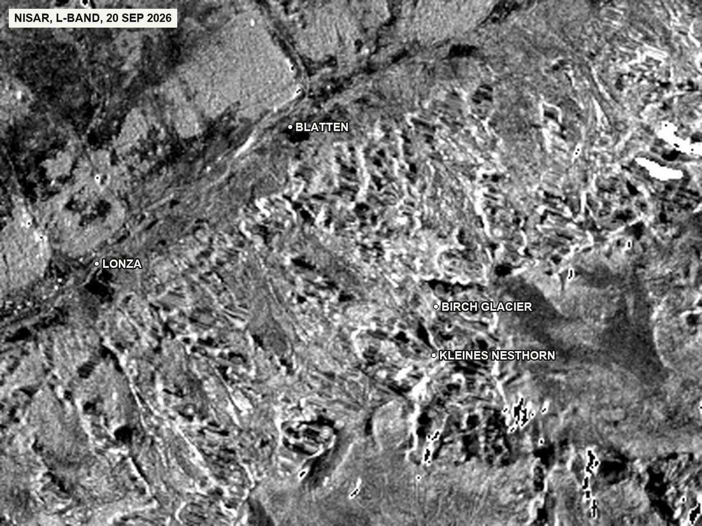NISAR, L-band: radar brightness of the image of 20 September 2026, 20 m detail. The longer wavelength shows the terrain more evenly, including the snow and ice at the lower right. Shown for comparison only; no assessment is made from it.